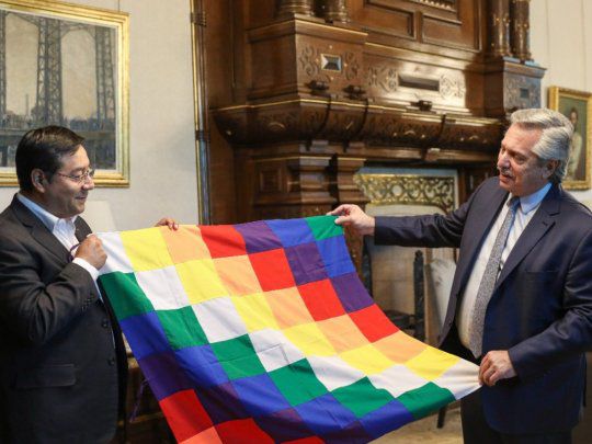 luis arce y alberto fernandez sosteniendo una whipala simbolo los pueblos originarios bolivia